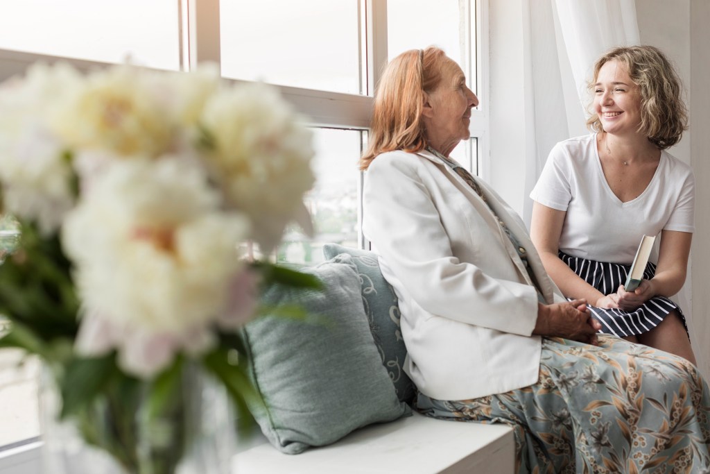 elderly with her caregiver smiling